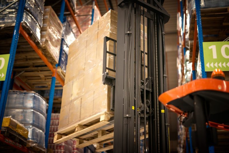 Modernus sandėlis su automatizuotomis saugojimo sistemomis ir skaitmeninėmis logistikos stebėjimo technologijomis.