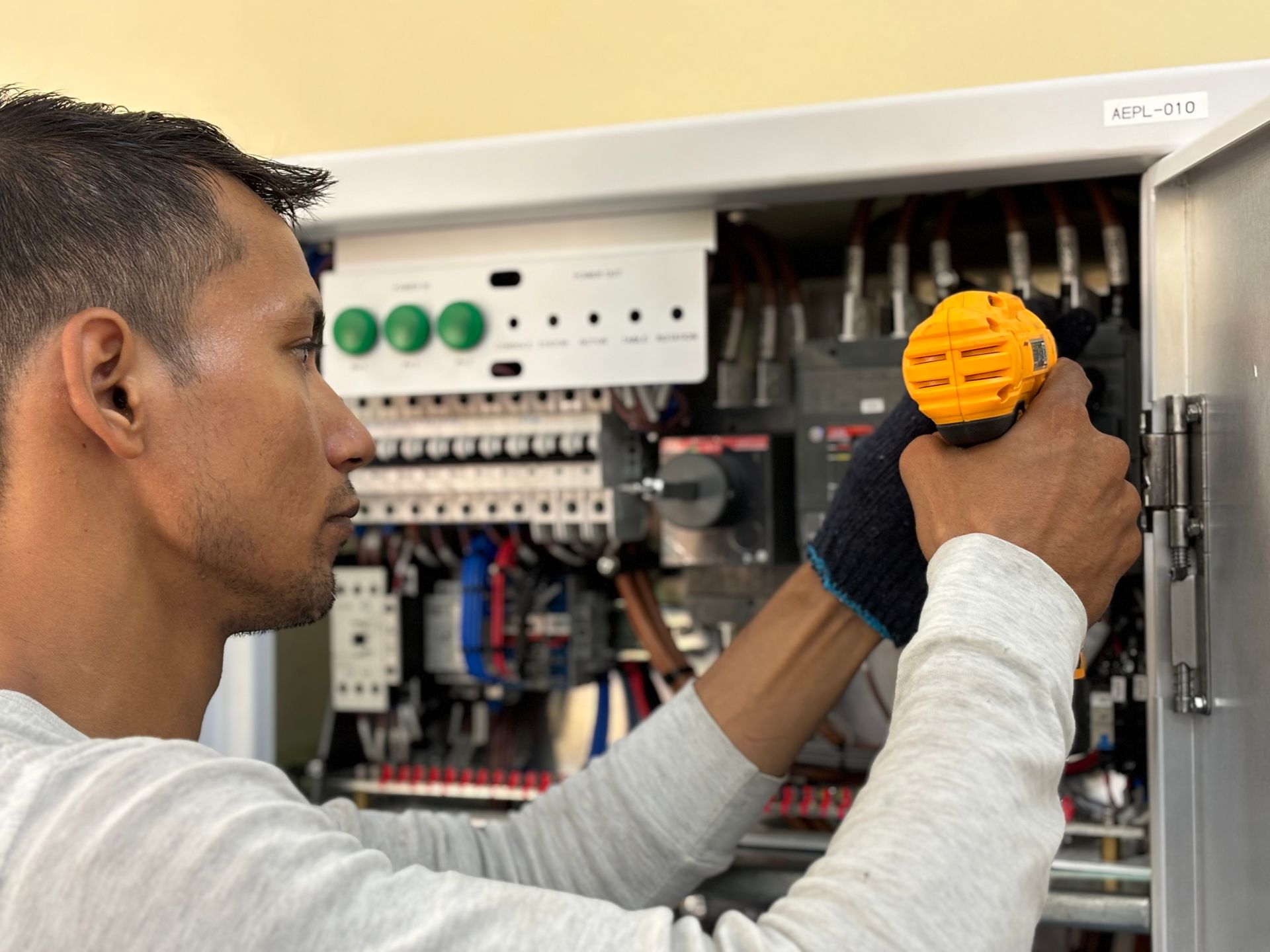 Elektrikas tikrina pramoninio elektros skydo būklę ir jungtis gamykloje